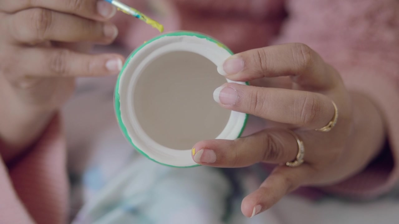 Close-up of a Person Painting the Rim of a Ceramic Pot