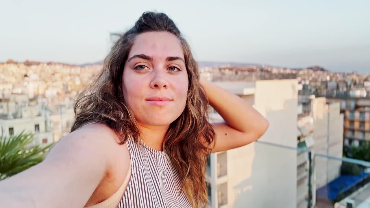 Woman Taking Selfie on Rooftop with City View, Athens, Greece.