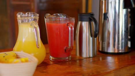 mesa de hotel con jugo de piña, fresa y cafetera con café de grano
