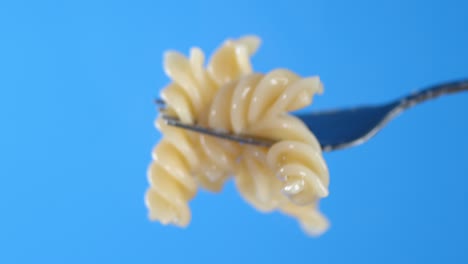 hot boiled fusilli pasta on a fork.