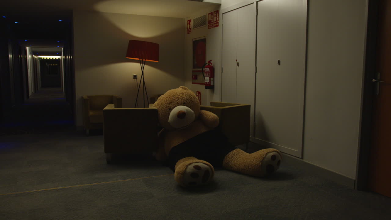 Large Teddy Bear in a Hotel Corridor at Night