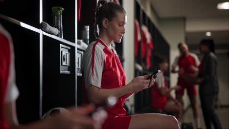 soccer player using cellphone in locker room