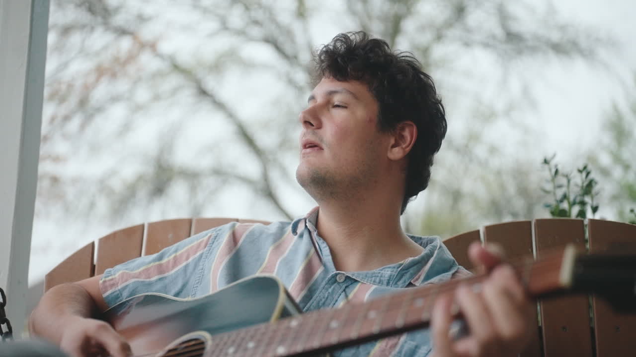 Man Playing Acoustic Guitar on Porch