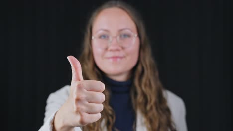 brunette beauty in glasses giving enthusiastic approval with thumb up gesture