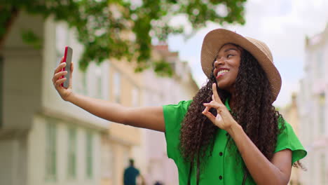 female tourist on vacation in oxford uk exploring city walking along holywell street posing for selfie on mobile phone