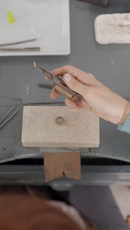 close-up of a hand crafting jewelry in a workshop