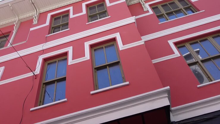 Edificio rosa con finestre e finiture bianche