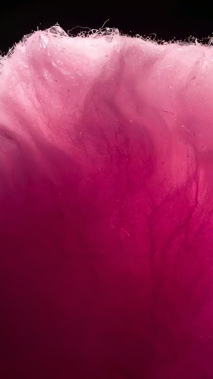 Vertical video: Spreading pink magenta dye plume mixing inside clear tank from droplet release