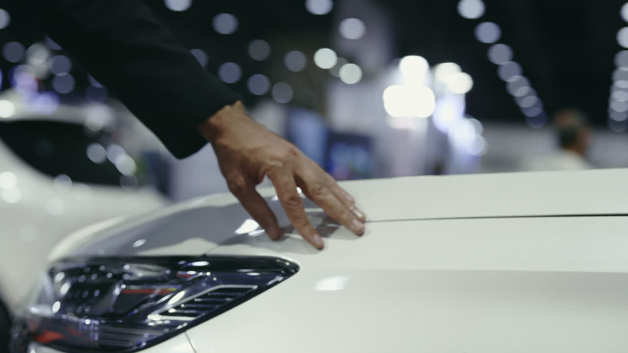 Man inspecting a white car at a showroom