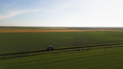 green agriculture landscape and tractor, aerial drone view
