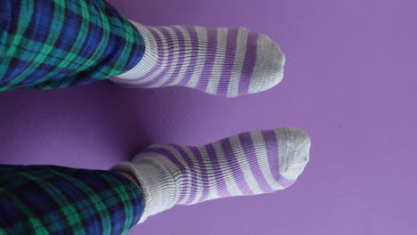 person wearing striped socks and plaid pajamas