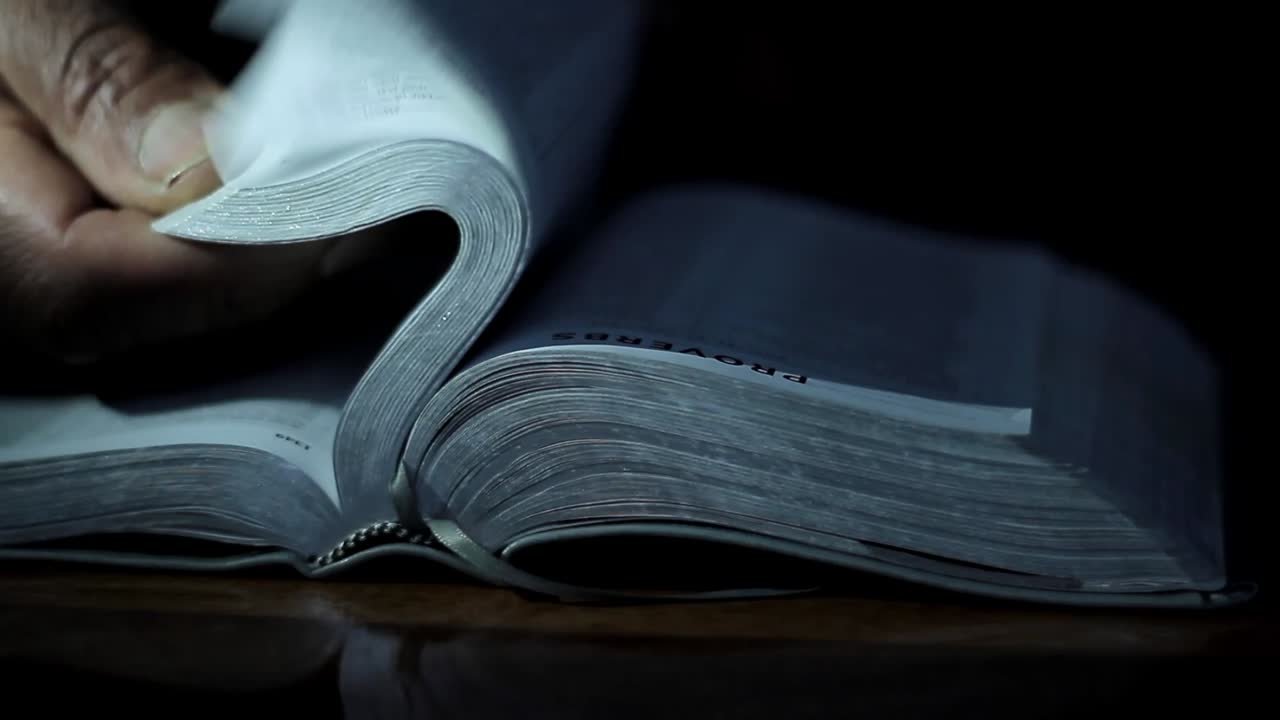 orando a dios con la mano en la biblia negra