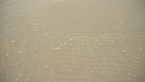 ocean waves calmly glide through the sand 4k uhd