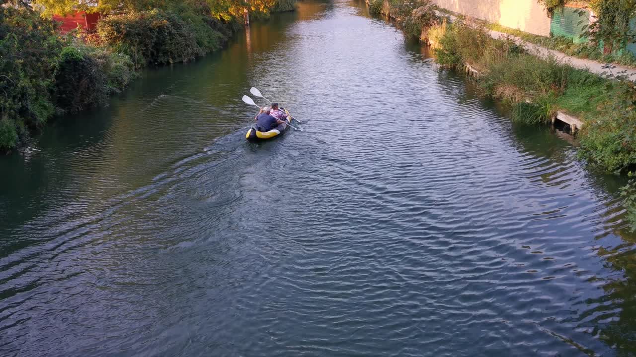 Due persone che navigano su un gommone a remi gonfiabile in un canale a Oxford, Regno Unito.