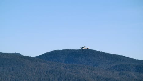 Kleines-Propellerflugzeug,-Das-An-Einem-Sonnigen-Tag-über-Bewaldete-Hügel-Fliegt