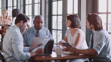 business team having informal meeting around table in coffee shop