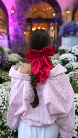 woman with red bow and pink plaid shirt