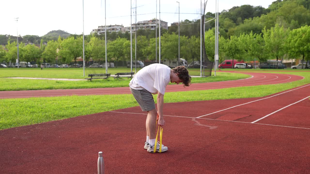 Man Exercising with Hula Hoop on Running Track