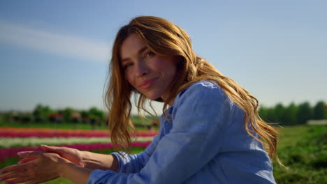 beautiful view of fresh green grass and happy woman relaxing in sunny tulip park