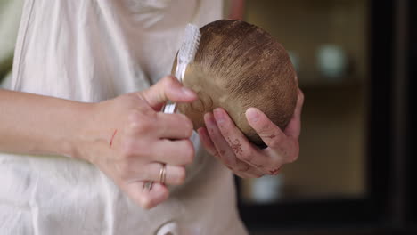 mujer tallando y preparando un cuenco de coco