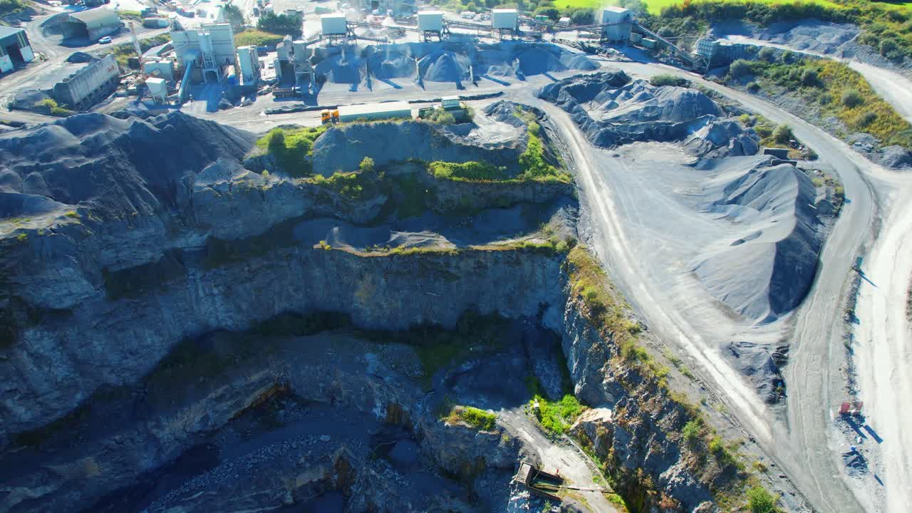 Mining drone view flying over working deep quarry in summer