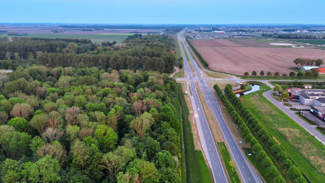 spring fields by the forest. a landscape showcases a highway lined with lush greenery and expansive agricultural fields under a clear sky in spring