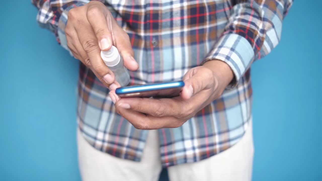 limpieza de un teléfono inteligente con desinfectante de manos