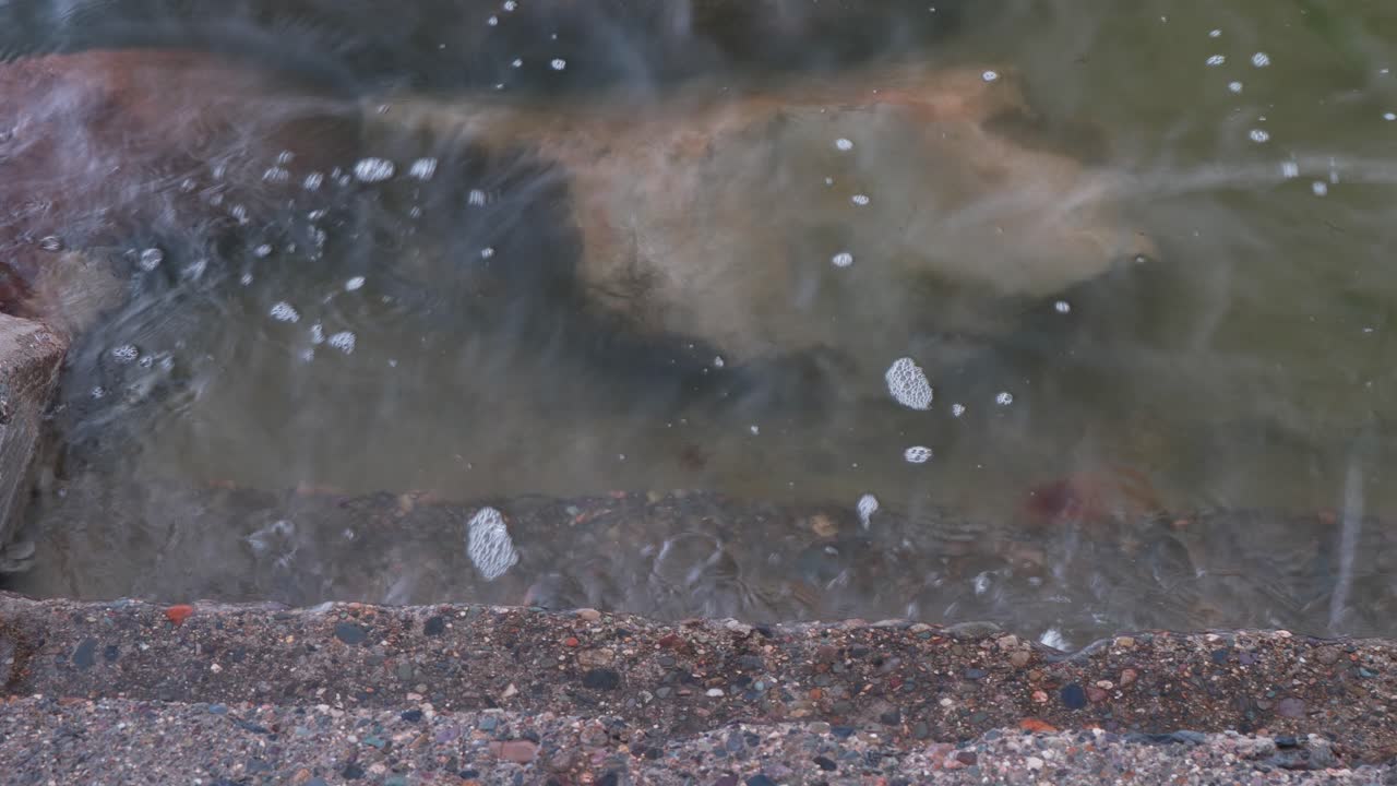 прозрачная океанская вода мягко стекает по каменным ступеням под крутым углом