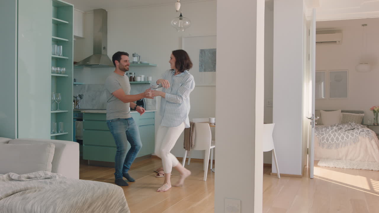 giovane coppia felice che balla a casa che si gode la danza insieme che si diverte che celebra la relazione
