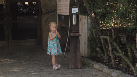 niña pequeña usando desinfectante de manos en el exterior