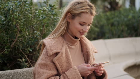 una mujer joven usando el teléfono al aire libre.