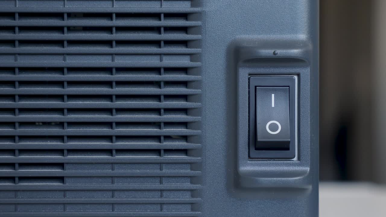 el dedo de una persona presiona se enciende y se apaga en un botón de plástico negro