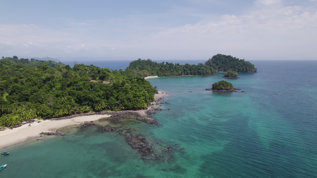 Aerial view of a tropical island with a beautiful beach and clear turquoise water