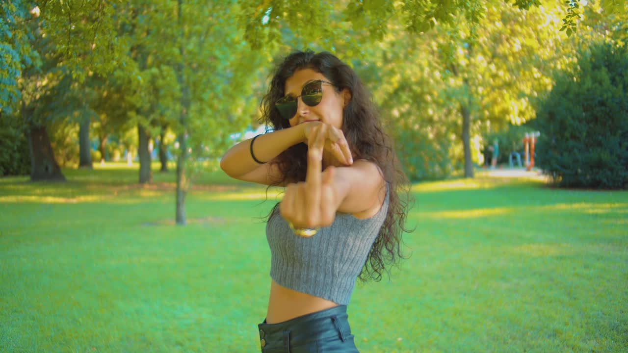 retrato de mujer joven sexy con gafas de sol mostrando el dedo medio de manera divertida