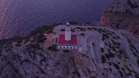 orbit around famous lighthouse cap formentor mallorca during sunrise, aerial