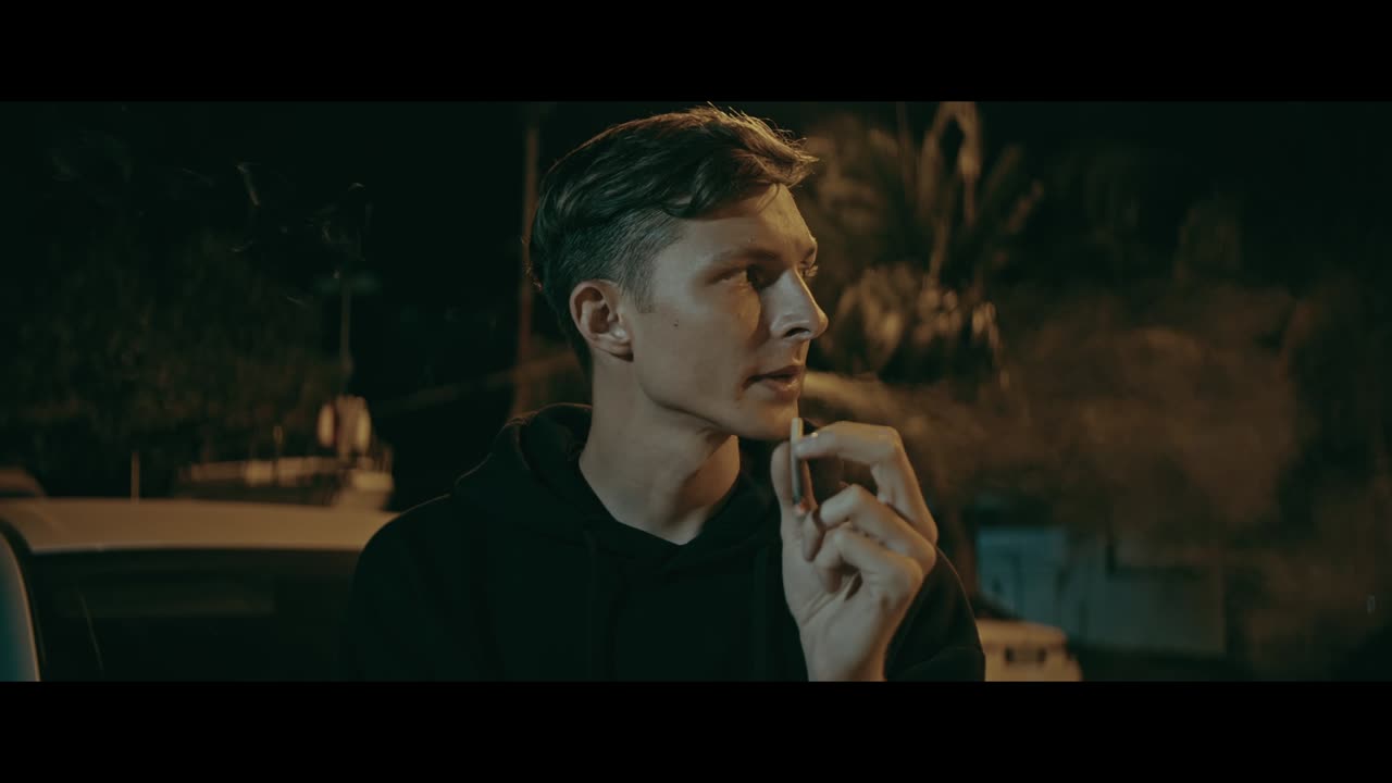 Young Man Smoking Outside at Night