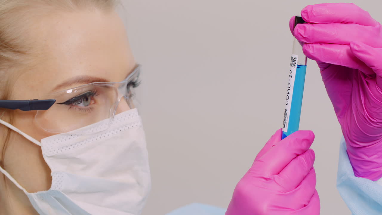 investigador sosteniendo el tubo de muestra covid 19 en la mano