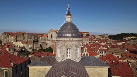 pedestal drone shot moving up the front of the cathedral of the assumption of the virgin mary in dubrovnik, croatia to reveal the church of st