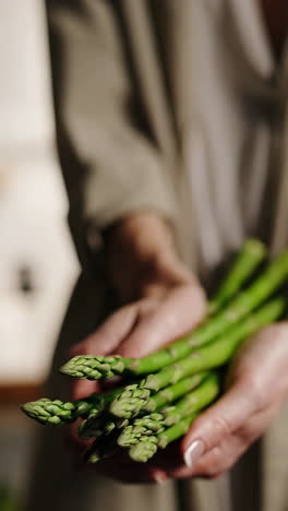 hands holding fresh green asparagus