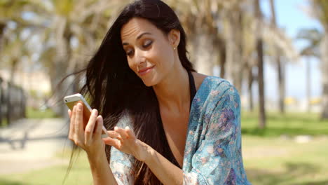 Pretty-Lady-in-Beach-Wear-Using-her-Mobile-Phone