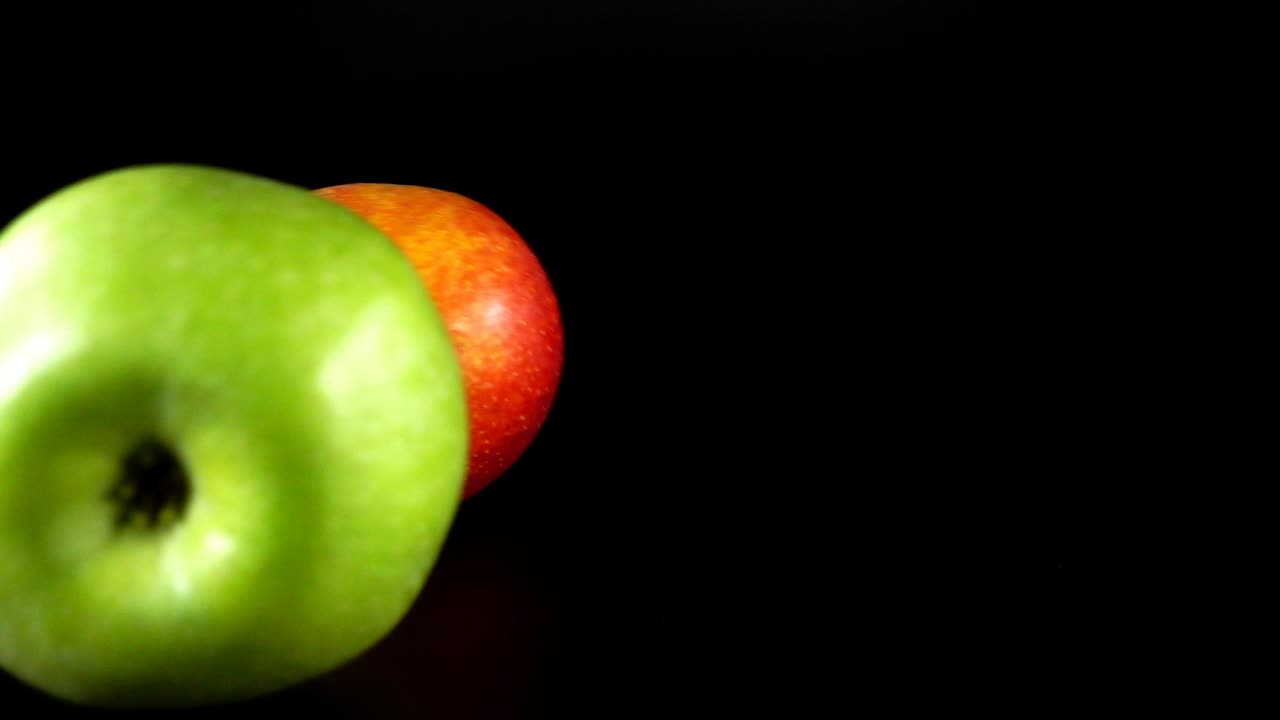 Glidende æble på en sort baggrund. Slowmotion.
