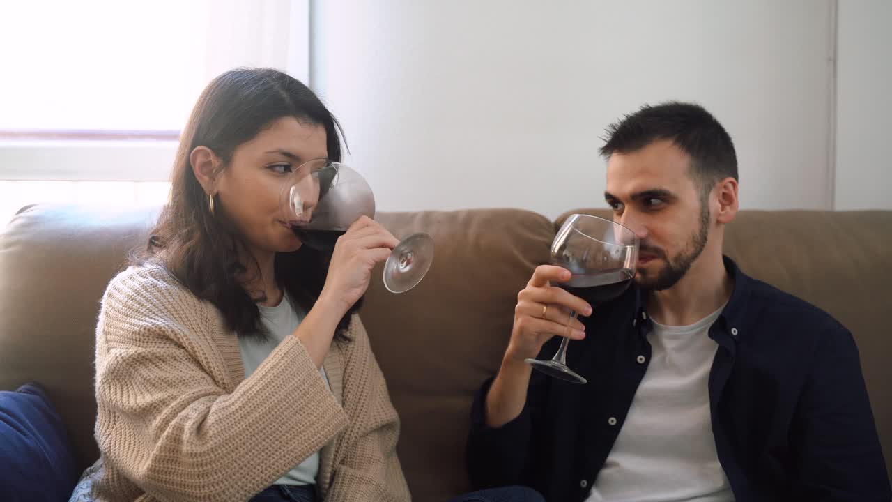 pareja sonriente con copas de vino en casa