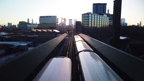 sunrise over city of chicago subway station with two trains