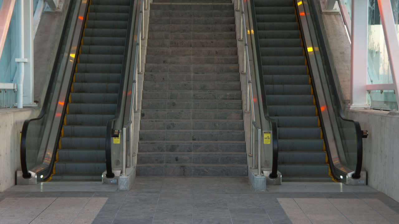two empty escalators waiting for commuters to show up.  One going up and one going down.