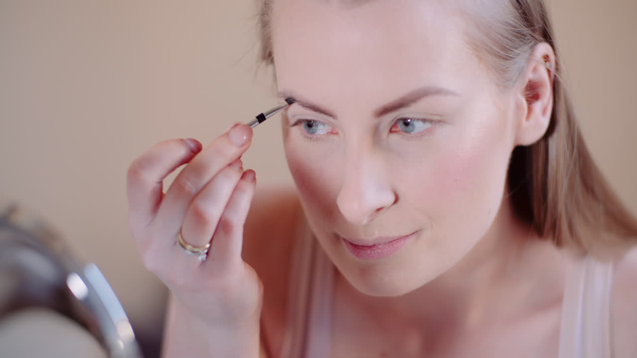 mujer maquillándose pintando pestañas con rímel 1