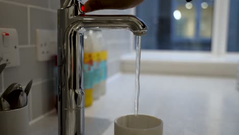 Una-Persona-Toma-Un-Refrescante-Sorbo-De-Agua-Directamente-Del-Grifo-En-Una-Taza