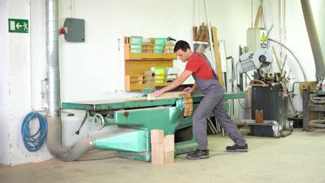carpenter working on a woodworking machine in a workshop