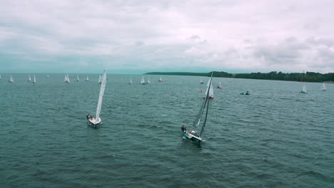 aerial view of drone flying towards the yachts racing in regatta on the sea