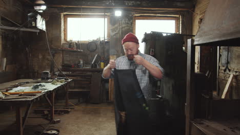 Blacksmith-Putting-on-Apron-and-Preparing-for-Work-in-Smithy