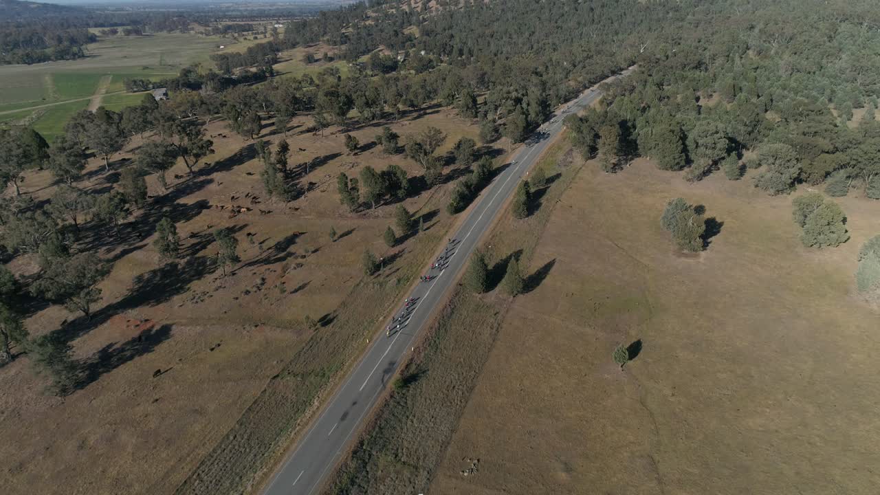 Aerial view of large group of cyclists taking on a hill climb in the popular Gears and Beers race held in the rural city of Wagga Wagga NSW Australia surrounded by beautiful country landscape.